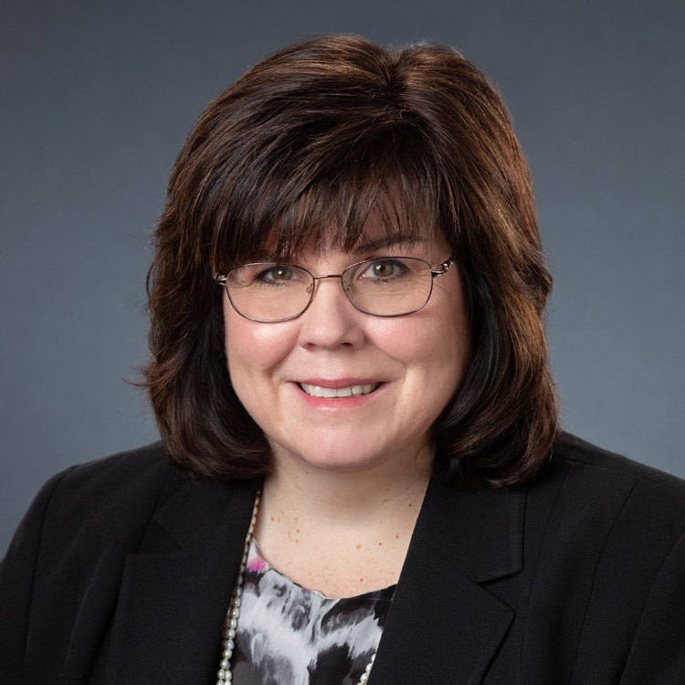 a person wearing glasses and smiling at the camera